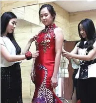  ?? NURUL KOMARIYAH/JAWA POS ?? JATUH HATI: Desainer Renee Couture Gisela Ekachristi­e (kiri) dan Melissa Anggono (kanan) membantu Olivya Pramono melakukan final fitting cheongsam untuk keperluan pesta sangjit.