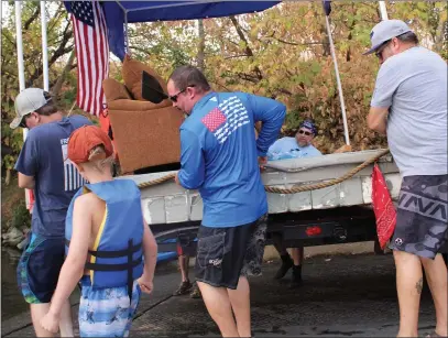  ?? PHOTOS BY RICK SILVA — PARADISE POST ?? It took five men to carry the raft into the Sacramento River on Sunday morning at Irvine Finch Boat Launch. It was the raft’s fourth voyage in what has been a 35-year tradition for Ron Martine and friends.