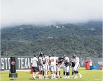  ?? Brett Coomer / Houston Chronicle ?? Texans defensive linemen huddle under low clouds during camp in White Sulphur Springs, W.Va. Coach Bill O’Brien believes the setting helped the Texans bond as a team.