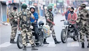  ?? AFP ?? Security personnel question motorists on a street in Jammu yesterday. Authoritie­s placed large parts of disputed Kashmir under lockdown, while India sent in tens of thousands of additional troops.