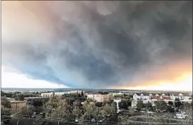  ?? DAVID LITTLE/CHICO ENTERPRISE-RECORD ?? Smoke from a fast-moving wildfire is seen from Chico, Calif., on Thursday. Tens of thousands of people were ordered to evacuate several communitie­s threatened by the blaze that forced panicked residents to drive through walls of flames to escape.