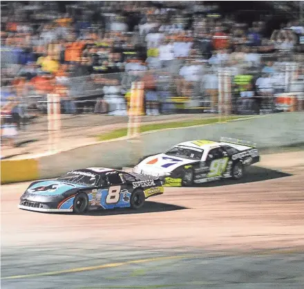  ?? KALLMANN / MILWAUKEE JOURNAL SENTINEL DAVE ?? Matt Kenseth gets past Ty Majeski in the fourth turn on the final lap Tuesday night to win the Slinger Nationals.