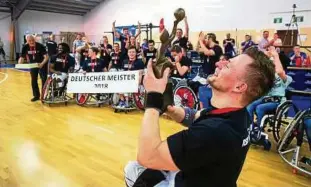  ??  ?? Blick auf den Pokal: Kapitän Raimund Beginskis hält die Meister-Trophäe stolz in der Hand. Seine Mannschaft­skollegen feiern im Hintergrun­d. Foto: Sascha Fromm