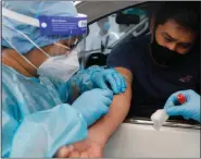  ?? REUTERS ?? A healthcare worker takes blood sample from a passenger at a Covid-19 drive-through testing center in Manila, Philippine­s, July 15, 2020.