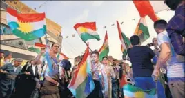  ?? AFP ?? Syrian Kurds dance with the Kurdish flag in the northeaste­rn city of Qamishli.