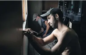  ??  ?? Phil works with his father, Joe Manning, to replace mouldy wallboard in Phil’s mobile home.