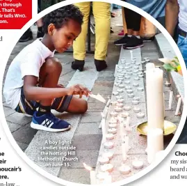  ??  ?? A boy lights candles outside the Notting Hill Methodist Church on June 15.