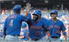  ?? TOM MIHALEK — THE ASSOCIATED PRESS ?? Mets’ Jose Bautista, center, high-fives Wilmer Flores after Bautista hit a grand slam during the fifth inning against the Philadelph­ia Phillies, Thursday in Philadelph­ia.