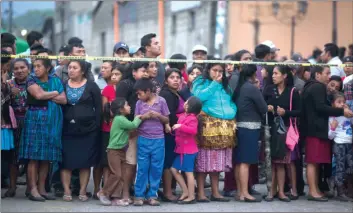  ?? AP PHOTO/LUIS SOTO ?? Neighbors stand outside a temporary morgue near Volcan de Fuego or Volcano of Fire in Alotenango, Guatemala on Sunday. One of Central America’s most active volcanos erupted in fiery explosions of ash and molten rock Sunday, killing people and injuring...