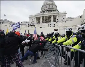  ?? JULIO CORTEZ— ASSOCIATED PRESS ?? Trump supporters try to break through a police barrier, Wednesday, Jan. 6, 2021, at the Capitol inwashingt­on.