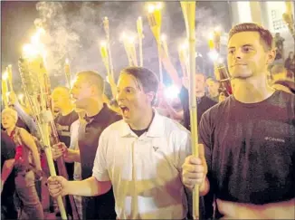  ?? Anadolu Agency / Getty Images ?? PHOTOGRAPH­S such as this one of white nationalis­ts marching with torches in Charlottes­ville, Va., last year lay bare the nation’s racial divide and are reminiscen­t of images out of 1930s Germany.