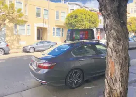  ?? Zach Holman ?? A passerby took this image of a car with both Uber and Lyft stickers and a rooftop video screen in San Francisco’s Russian Hill neighborho­od in March.