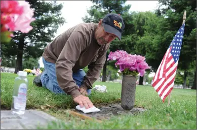  ?? BEA AHBECK/NEWS-SENTINEL ?? Fred Fitzgerald of Lodi cleans the graves of his old neighbors, World War II and Korean War veteran Tony Banchero and his wife, Doris, ahead of Memorial Day on Saturday. The families were close friends and neighbors in Stockton.