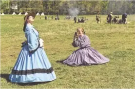  ??  ?? Ladies in antebellum gowns pose for photos.