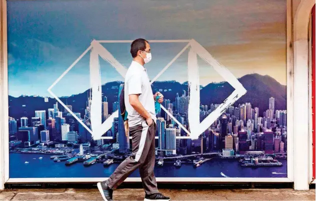  ?? Agence France-presse ?? ↑
A pedestrian walks past a HSBC sign in Hong Kong. Shares in banking giant HSBC plunged to a 25-year low on Monday.