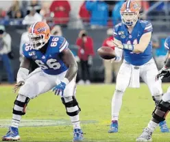  ?? JOHN RAOUX/AP ?? UF quarterbac­k Kyle Trask takes a snap from center and longtime teammate Nick Buchanan during the Gators’ 24-17 loss against Georgia Nov. 2 in Jacksonvil­le.