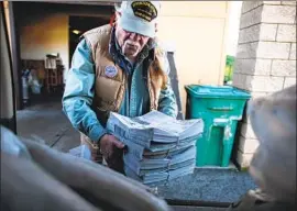  ??  ?? SCOTT McDERMID loads fresh copies of the Mountain Messenger into the trunk of a car in Quincy, Calif. It has a circulatio­n of about 2,400 on its best day.