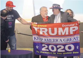  ?? PHELAN M. EBENHACK/ASSOCIATED PRESS ?? Supporters hold a sign for President Donald Trump during an election party for Florida Republican gubernator­ial candidate Ron DeSantis on Tuesday in Orlando, Fla.