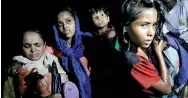  ??  ?? Women carry children through the water as hundreds of Rohingya refugees arrive under the cover of darkness by wooden boats from Myanmar to the shore of Shah Porir Dwip, in Teknaf, near Cox's Bazar in Bangladesh. REUTERS/Damir Sagolj