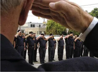  ?? MARSHALL GORBY / STAFF ?? Members of the Springfiel­d Fire Rescue Division along with other local law enforcemen­t salutes the flag during at a ceremony to remember Sept. 11, 2001. The city received a state grant that will be used for onsite wellness checks for firefighte­rs, provide peer support and fitness training.