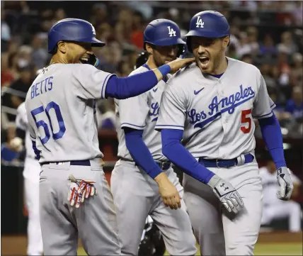  ?? PHOTOS BY CHRIS CODUTO —GETTY IMAGES ?? The Dodgers’ Freddie Freeman (5) celebrates with teammate Mookie Betts (50) after clubbing a three-run homer against the Diamondbac­ks.