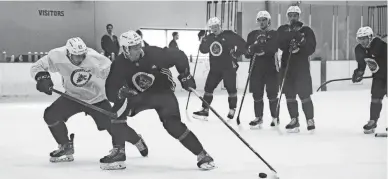  ?? MEGAN MENDOZA/THE REPUBLIC ?? Markus Vidicek, left, and Dylan Guenther move down the ice as their teammates watch at the Coyotes’ rookie camp on Thursday at the Ice Den in Scottsdale.