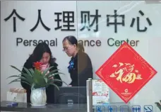  ?? XU JINBO / FOR CHINA DAILY ?? A financial manager (right) talks to a client at a State-owned commercial bank in Hai’an, Jiangsu province.