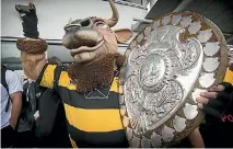  ?? PHOTO: GRANT MATTHEW/STUFF ?? Taranaki mascot Ferdinand the Bull shows off the Ranfurly Shield to fans at New Plymouth Airport.