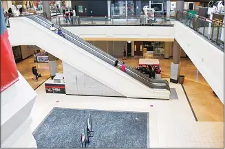  ?? (AP) ?? In this file photo, people ride down an escalator at a shopping mall in Oklahoma City as it reopens from its closure since mid-March due to coronaviru­s concerns. Many businesses are requiring customers and workers to sign forms saying they won’t sue if they catch COVID-19.
Businesses are afraid they could face lawsuits even if they follow social distancing and other government guidelines as they reopen across the US after coronaviru­s shutdowns.