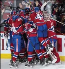  ?? PAUL CHIASSON/THE CANADIAN PRESS VIA AP ?? Members of the Montreal Canadiens pile on teammate Alexander Radulov after he scored the winning goal against the Rangers during overtime in Game 2 of their first-round series Friday in Montreal.