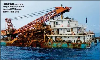  ??  ?? LOOTING: A crane barge pulls up metal from a WWII wreck in the Java Sea