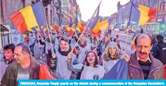  ?? — AFP ?? TIMISOARA, Romania: People march on the streets during a commemorat­ion of the Romanian Revolution’s first victims on Sunday.