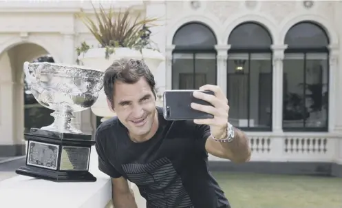  ??  ?? 0 Selfies are all the rage these days, as Roger Federer poses with the Norman Brookes Challenge Cup at Government House in Melbourne.