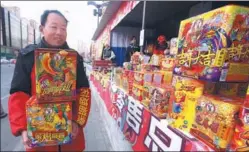  ?? CHEN XIAOGEN / FOR CHINA DAILY ?? A worker carries fireworks to put on display at a temporary sales outlet in Beijing’s Chaoyang district on Monday.