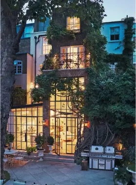  ??  ?? THIS PAGE (from top) At night, the precious wisteria provides a natural frame for light flowing through the Crittall-style windows. Alison with daughters, Olivia, left, and Anna Cristina. OPPOSITE The five-storey Georgian villa has a classic yew hedge at the front and a handsome wrought-iron gate that was once part of a country estate.