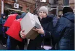  ?? ?? SLOVIANSK, Ukraine: A local resident carries a food kit distribute­d by volunteers of the NGO “ResponZPIS­L *P[PaLUZ¹ ^P[O [OL ÄUHUJPHS Z\WWVY[ VM [OL <2 Government, in Sloviansk, Donetsk region, Feb 26, 2024, amid the Russian invasion of Ukraine. — AFP