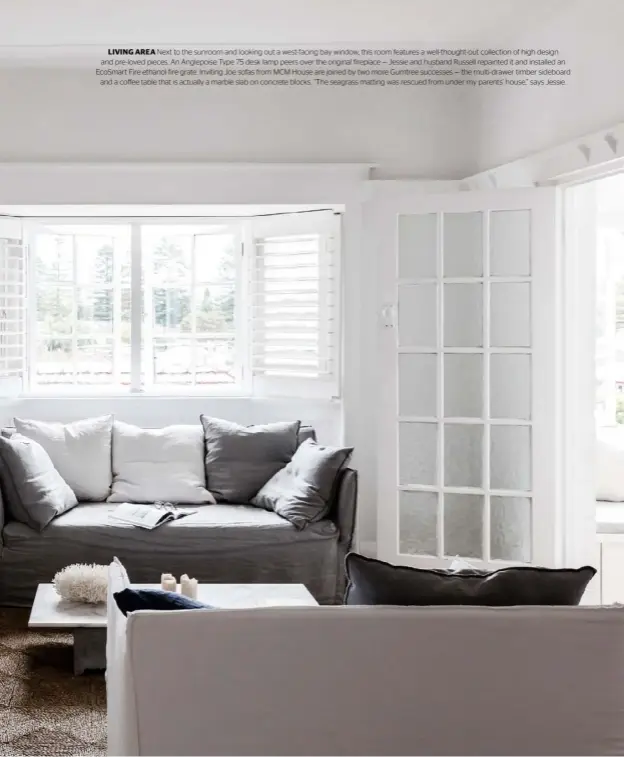  ??  ?? LIVING AREA Next to the sunroom and looking out a west-facing bay window, this room features a well-thought- out collection of high design and pre-loved pieces. An Anglepoise Type 75 desk lamp peers over the original fireplace — Jessie and husband Russell repainted it and installed an EcoSmart Fire ethanol fire grate. Inviting Joe sofas from MCM House are joined by two more Gumtree successes — the multi-drawer timber sideboard and a coffee table that is actually a marble slab on concrete blocks. “The seagrass matting was rescued from under my parents’ house,” says Jessie.