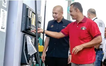  ?? — Bernama photo ?? Armizan watches as a lorry driver uses the Fleet Card to purchase diesel at a petrol station.