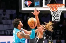  ?? — AFP photo ?? Miles Bridges (left) of the Charlotte Hornets goes up for a shot against Nic Claxton of the Brooklyn Nets at Barclays Centre in New York City.