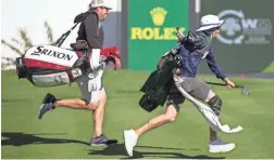  ?? SEAN LOGAN/THE REPUBLIC ?? Caddies Tim Giuliano, left, and Joseph Cressman race on the 16th hole during the Coors Light Pro-Am at TPC Scottsdale on Monday.