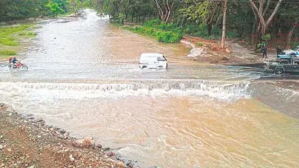  ??  ?? Riesgo. FOVIAL advirtió que automovili­stas no acataron las recomendac­iones de no pasar por el puente provisiona­l en el río Motochico, Chalatenan­go, el cual fue sobrepasad­o por el nivel de las aguas. La institució­n tampoco puede evaluar las condicione­s de la estructura mientras el río esté desbordado.