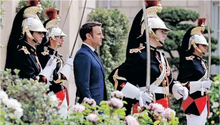  ?? | AFP ?? PRESIDENT Emmanuel Macron reviews troops in the gardens of Élysée Palace in Paris on Saturday after his investitur­e as French President, following his re-election last month.