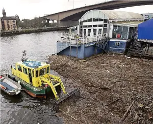  ??  ?? Debris: A boat clears up at the Renfrew Ferry, on the Clyde in Glasgow