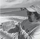  ?? ?? Turtle Time volunteer Barnhart displays sea turtle nesting stakes. Nests are marked with such stakes and yellow line and are protected by state and federal laws. Those laws also prohibit lighting on homes and signage that can be seen from the beach as the lights can attract hatchlings, which crawl toward light once they hatch.