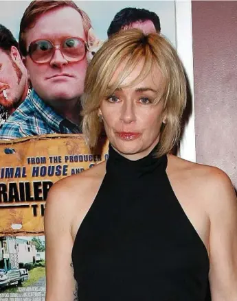  ?? MICHAEL BUCKNER/GETTY IMAGES FILE PHOTO ?? Lucy DeCoutere is seen in front of a poster promoting the first Trailer Park Boys movie during a publicity trip to Los Angeles in 2008. Michael Smith, who plays Bubbles (pictured in the poster), was charged with battery on Friday.