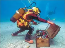  ?? BORIS HORVAT / AGENCE FRANCE-PRESSE ?? A diver removes wine bottles from an underwater trunk in the Mediterran­ean sea off SaintMandr­ier in southern France. The experiment was conducted to determine the effects on the maturing process of Bandol wines when stored under the sea for a period of...
