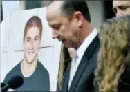  ?? ABBY DREY/CENTRE DAILY TIMES VIA AP ?? A large photo of Timothy Piazza is displayed next to his father Jim Piazza as he speaks about the importance of passing anti-hazing legislatio­n named after his son outside of the Centre County Courthouse on March 23 in Bellefonte. A forensic...