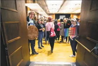  ?? Joseph Cress / Iowa City Press-Citizen ?? Elizabeth Warren supporter Lee Sailor (left) and Pete Buttigieg backer Joseph O’Kelly help University of Iowa students find candidate groups Monday during caucuses in Iowa City.