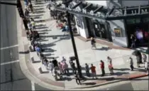  ?? SCOTT SOMMERDORF — THE SALT LAKE TRIBUNE VIA AP ?? In this Thursday photo, hopeful eclipse-watchers line up outside the Clark Planetariu­m in hopes of getting eclipse glasses from the gift shop in Salt Lake City. Eclipse mania is building and so is demand for the glasses that make it safe to view the...