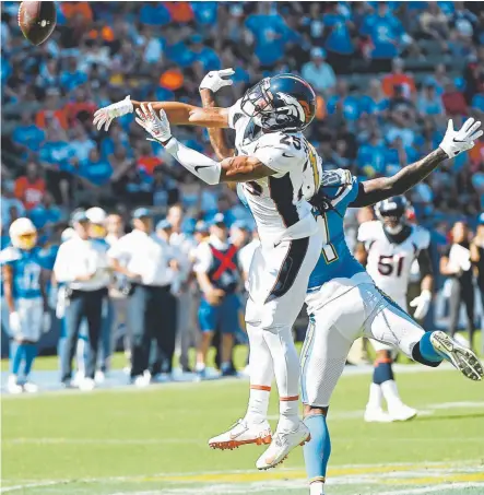  ?? Joe Amon, The Denver Post ?? Broncos cornerback Chris Harris deflects a pass Sunday that was intercepte­d by safety Justin Simmons.